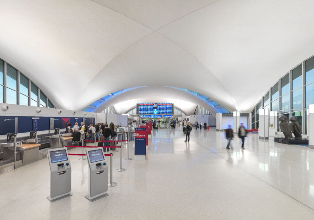 The inside of an airport with many people walking around.