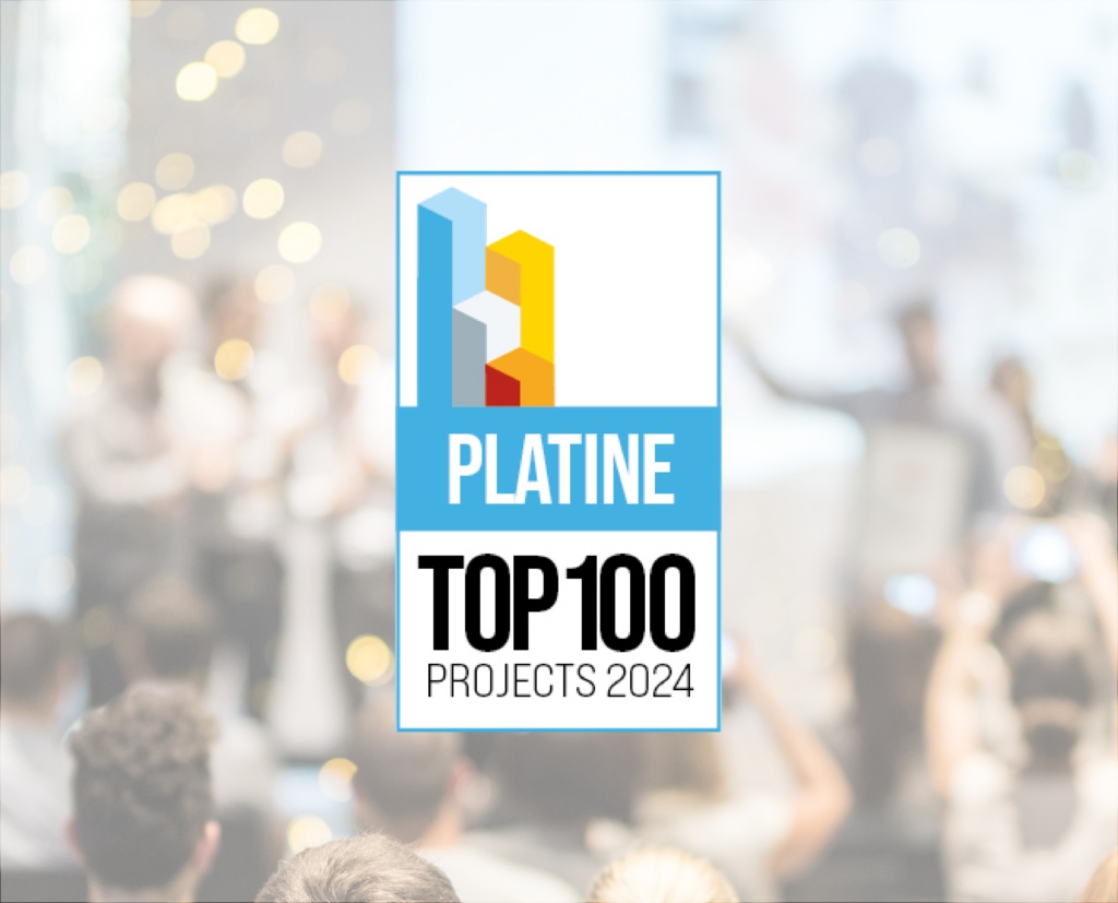 Une foule assistant à un événement concentré sur un podium. En superposition se trouve un logo indiquant « Platine Top 100 Projects 2024 ».