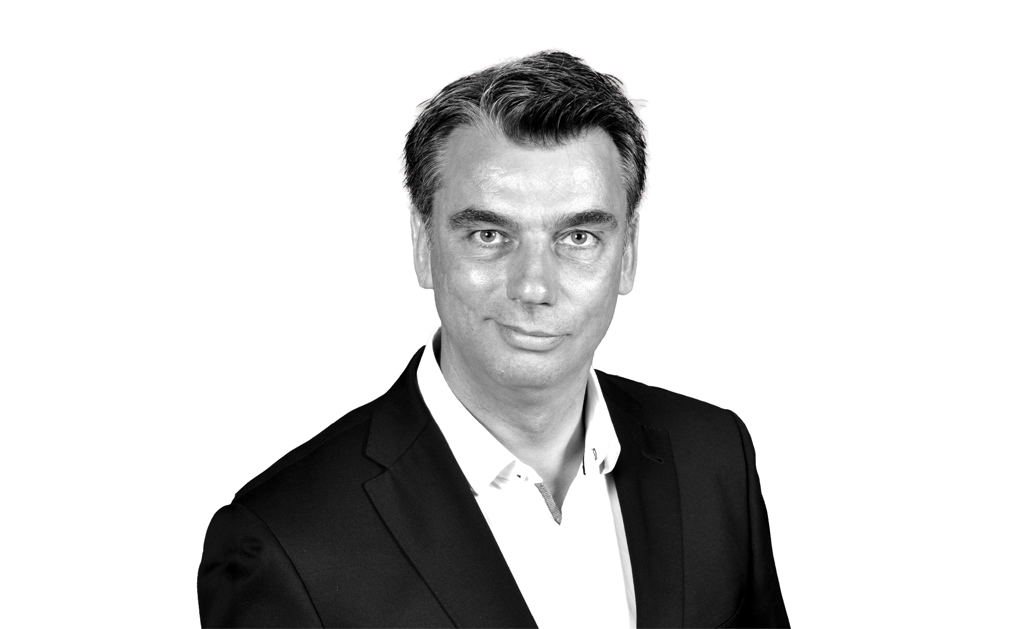 A grayscale headshot of a man with short hair wearing a dark suit jacket and white shirt, looking directly at the camera with a neutral expression.