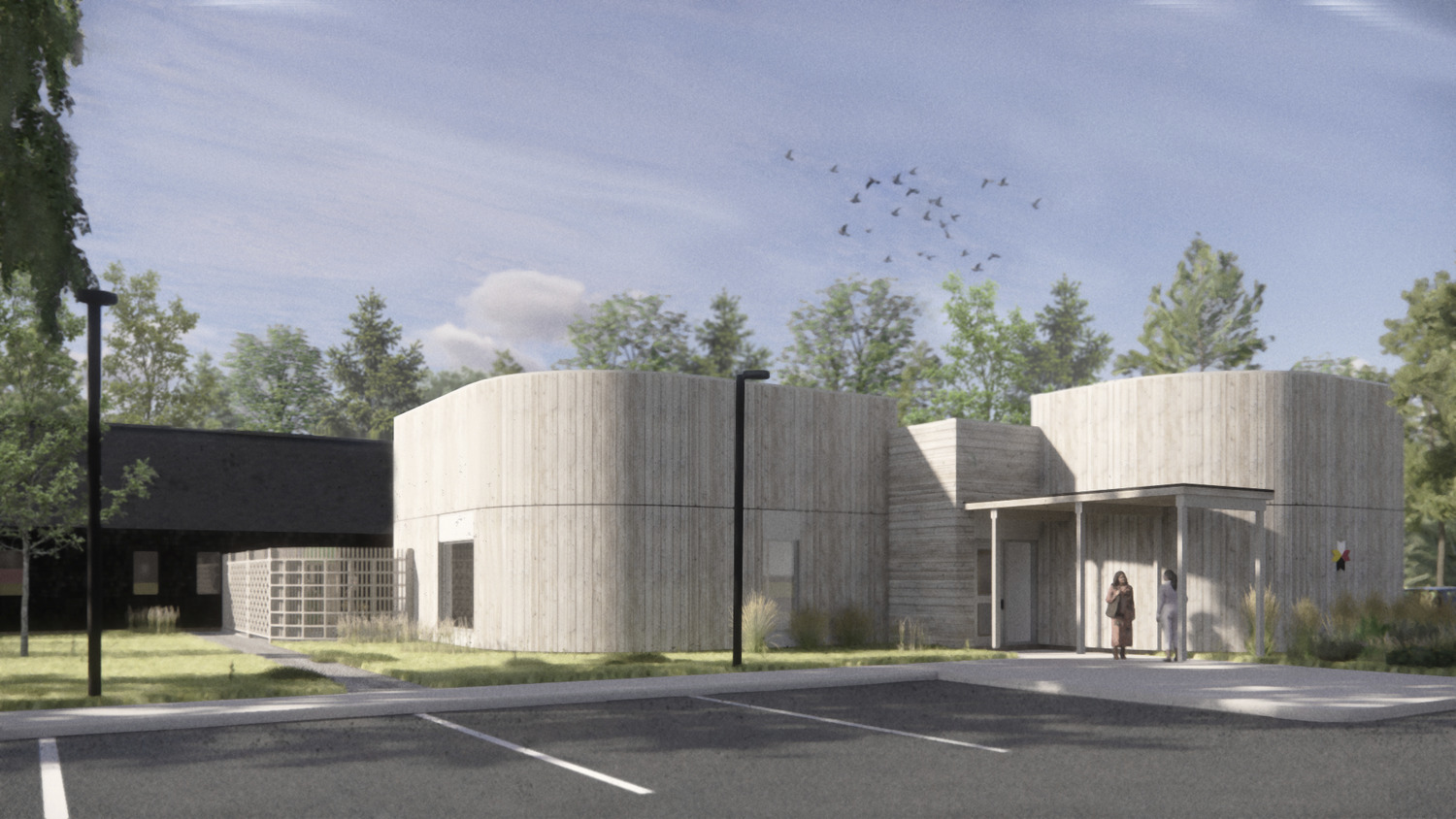 A modern building with a cylindrical design made of wood, surrounded by trees and with birds flying in the sky. A person stands near the entrance. There are empty parking spaces in the foreground.