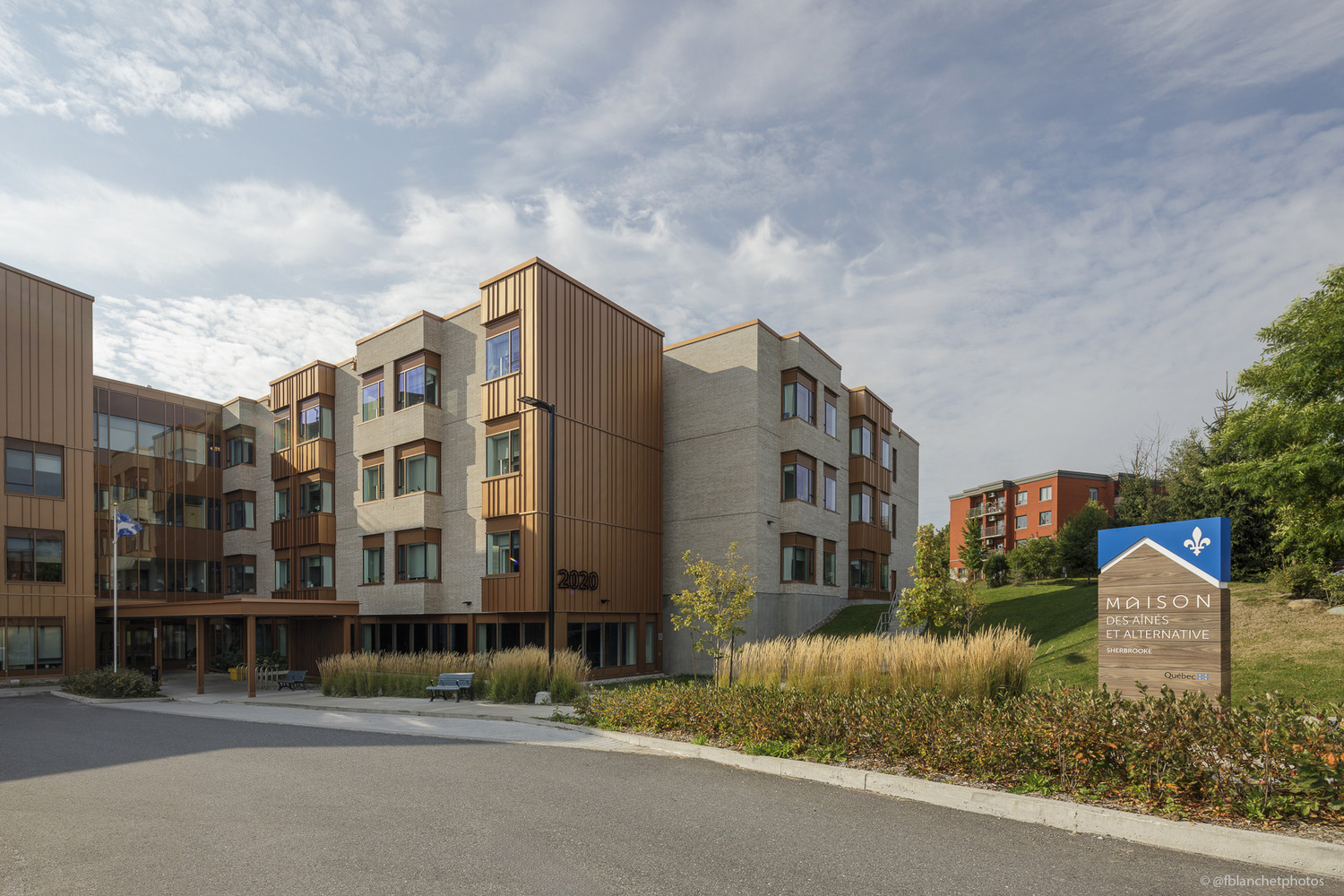 Front view of a modern multi-story building with a sign that reads 