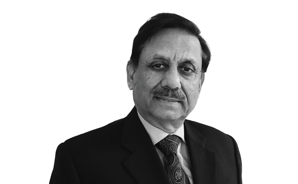 A man wearing a suit and tie poses against a plain white background.