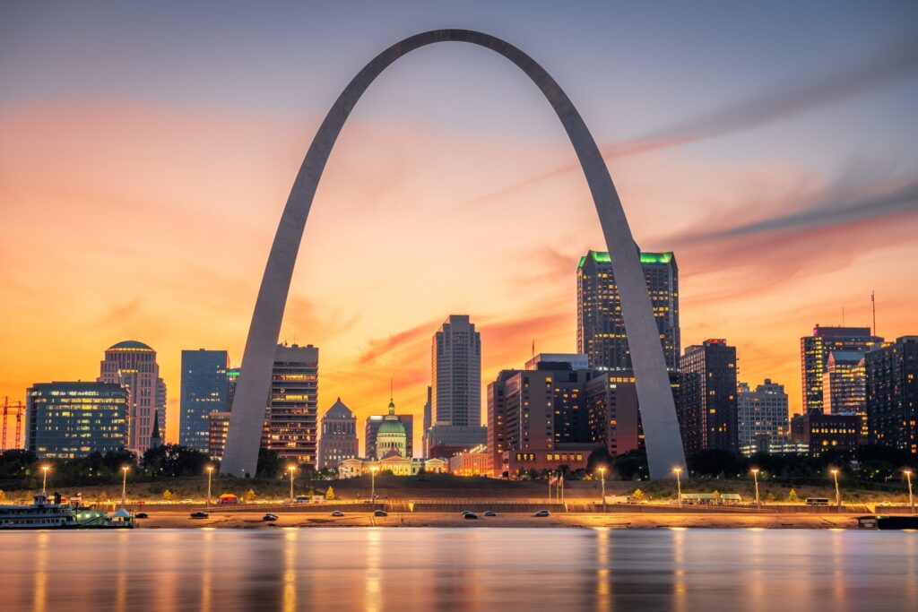 St. Louis cityscape at sunset, where the Gateway Arch and illuminated buildings reflect off the river, sets a perfect backdrop for the TEAM 2025 Annual Conference.